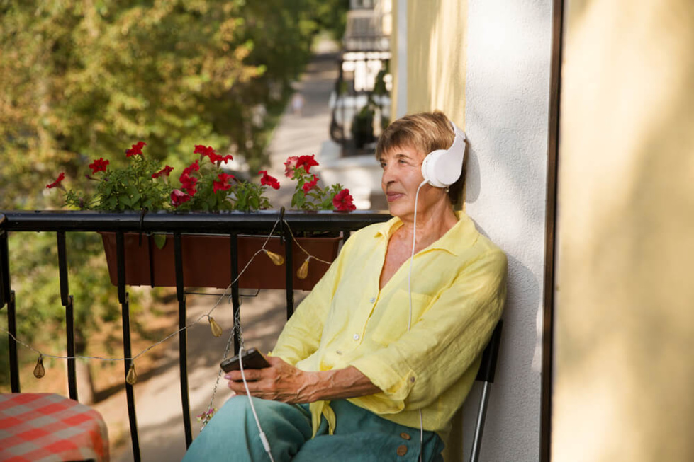 Femme senior écoutant un podcast sur on smartphone ©Shutterstock