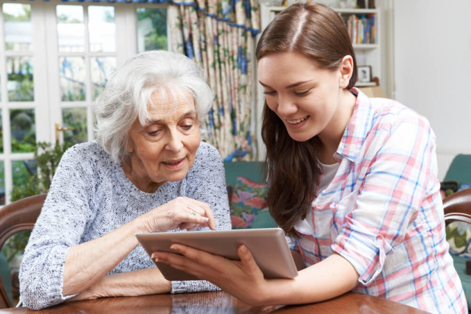 Femme âgée et sa petite-fille avec une tablette numérique ©Shutterstock