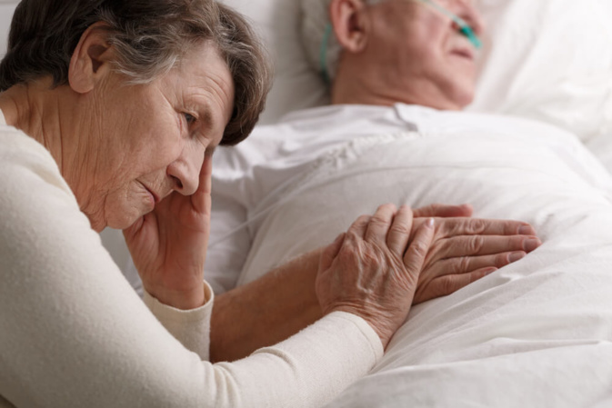 Femme âgée à côté de son mari en fin de vie ©Shutterstock