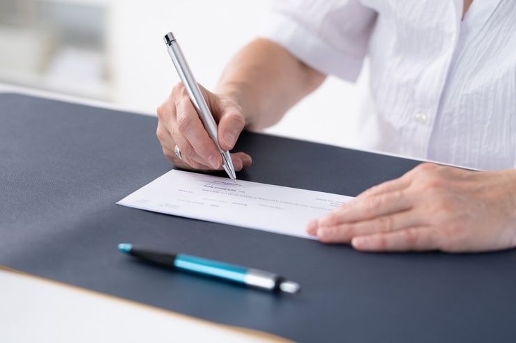 senior remplissant un chèque © Andrey_Popov/Shutterstock senior remplissant un chèque © Andrey_Popov/Shutterstock