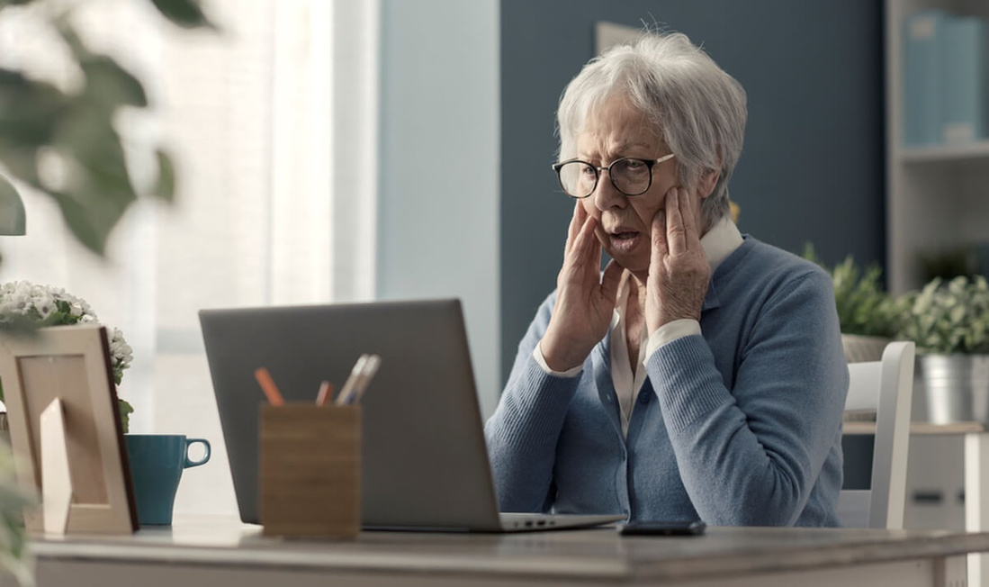 Femme aînée aux prises avec la technologie, elle est confuse et regarde l'écran d'ordinateur © Stock-Asso/Shutterstock