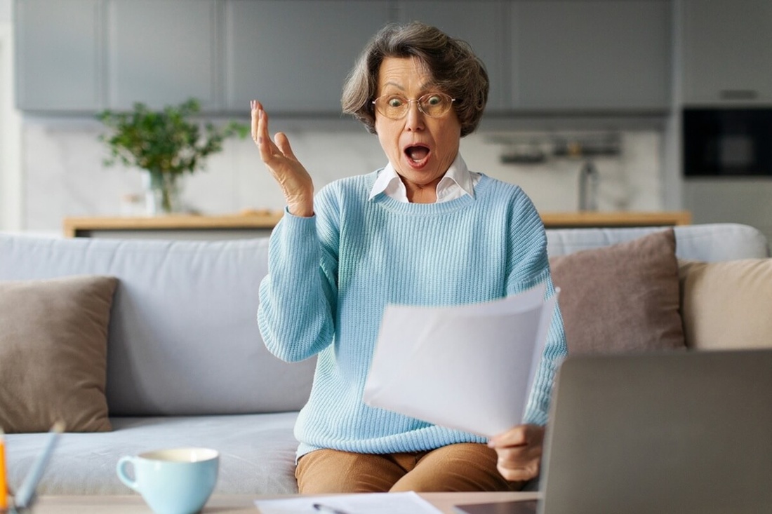 Un retraité examine ses factures d'énergie et ses relevés bancaires, symbole des hausses de prix du quotidien au 1er janvier 2026 © fast-stock/Shuttertock