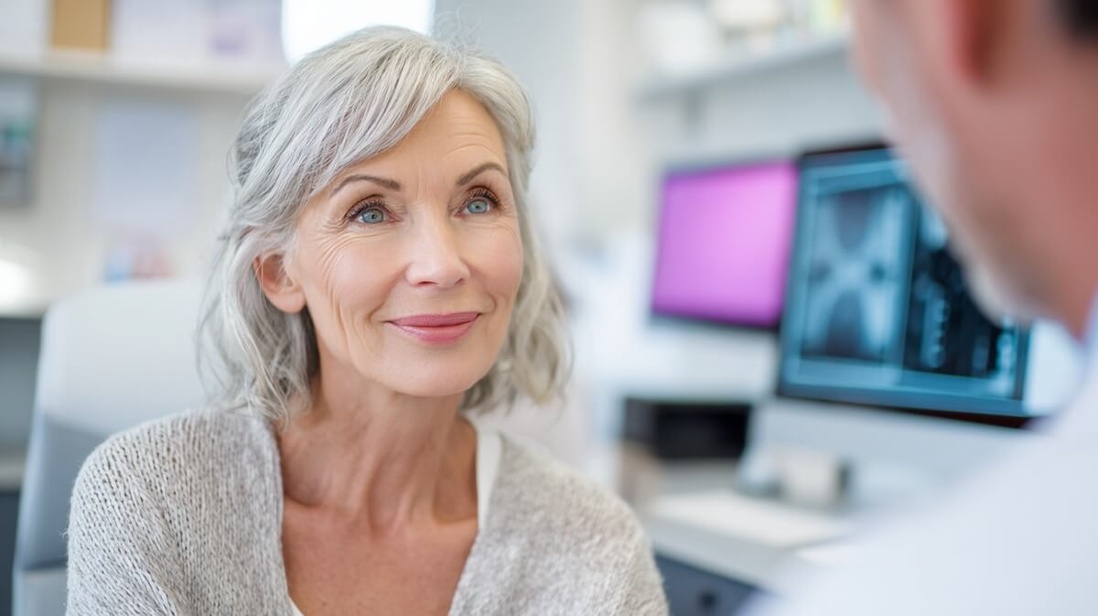 Une patiente senior atteinte d'un cancer consulte son médecin qui lui présente son dossier médical sur écran  © SenioraActu