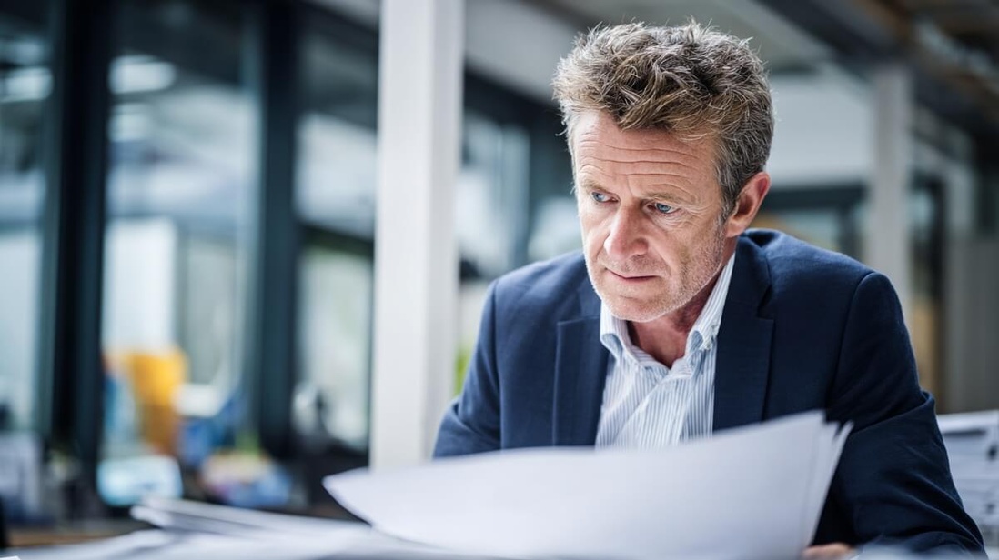 Directeur d'EHPAD examinant des documents financiers © SeniorActu