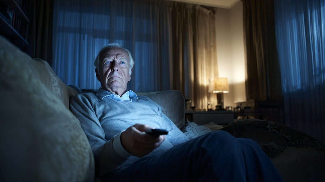Senior regardant la télévision seul illustrant les habitudes sédentaires à risque © SeniorActu