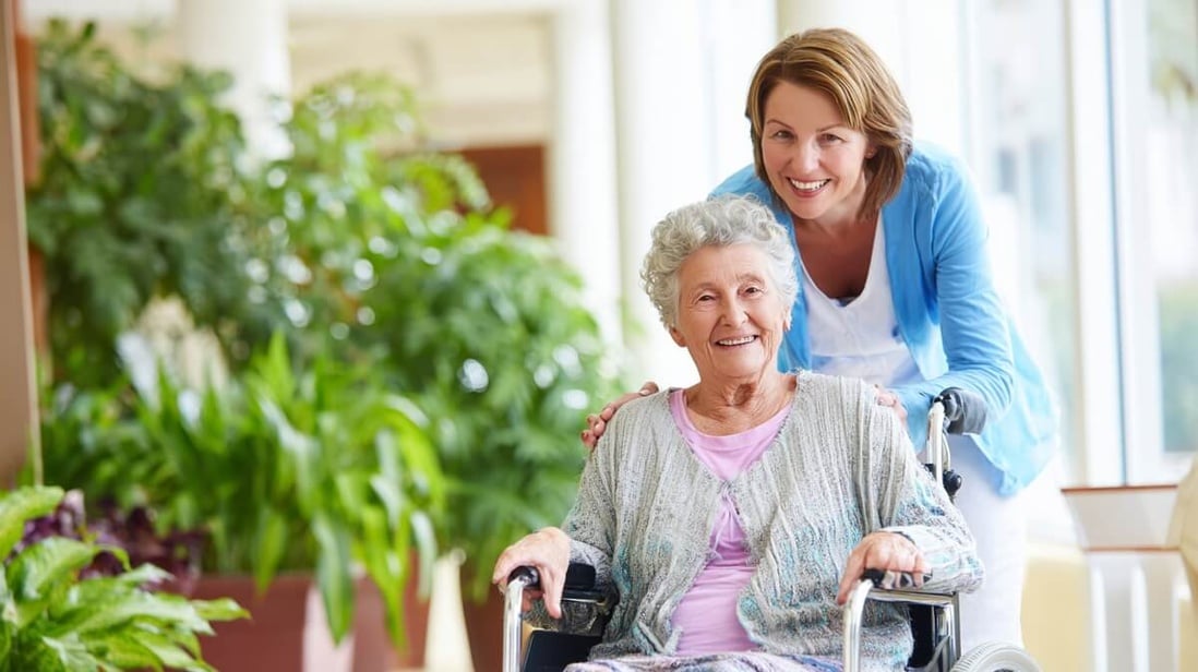 Une fille avec sa mère en fauteuil roulant dans le hall d'un EHPAD © SeniorActu Une fille avec sa mère en fauteuil roulant dans le hall d'un EHPAD © SeniorActu