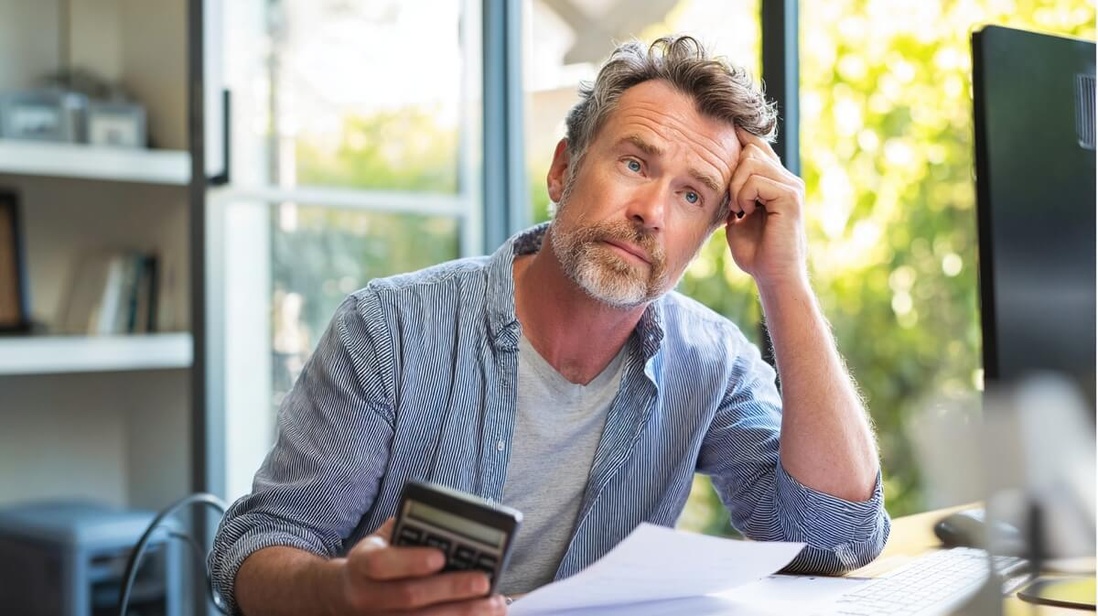 Homme de 55 ans calculant le coût d'un rachat de trimestres retraite © SeniorActu