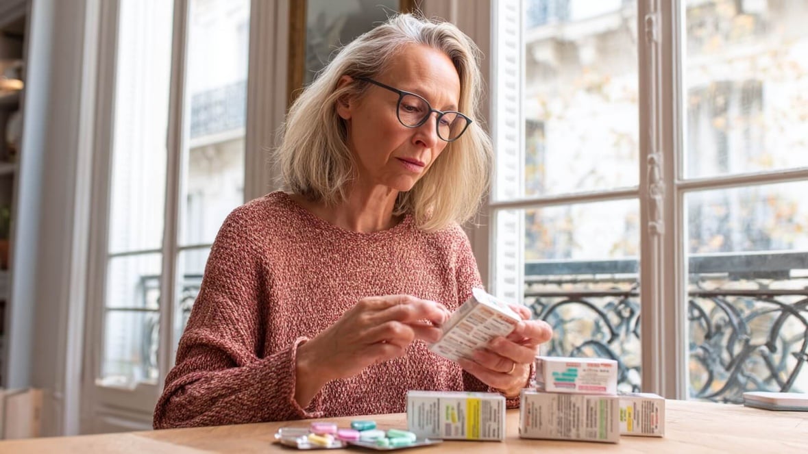 Femme senior organisant ses boîtes de compléments alimentaires © SeniorActu.com