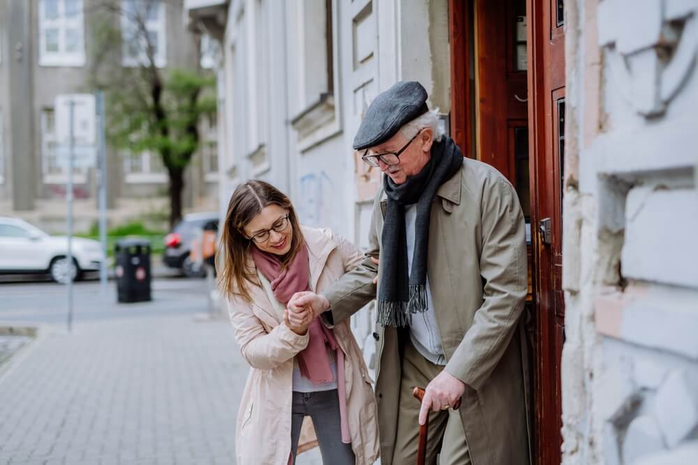 Femme aidant un homme âgé ©Shutterstock