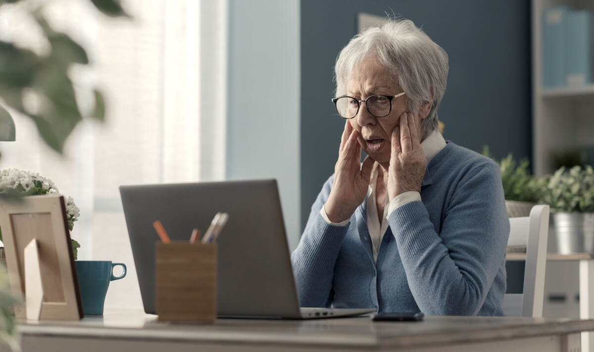 Femme aînée aux prises avec la technologie, elle est confuse et regarde l'écran d'ordinateur © Stock-Asso/Shutterstock