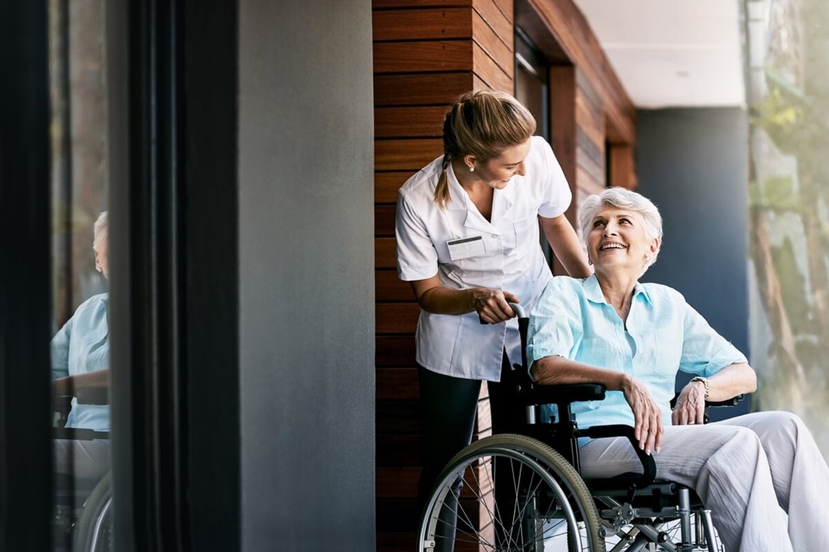 Une femme agée en maison de retraite avec une infirmière spécialisée en gériatrie © PeopleImages/Shutterstock