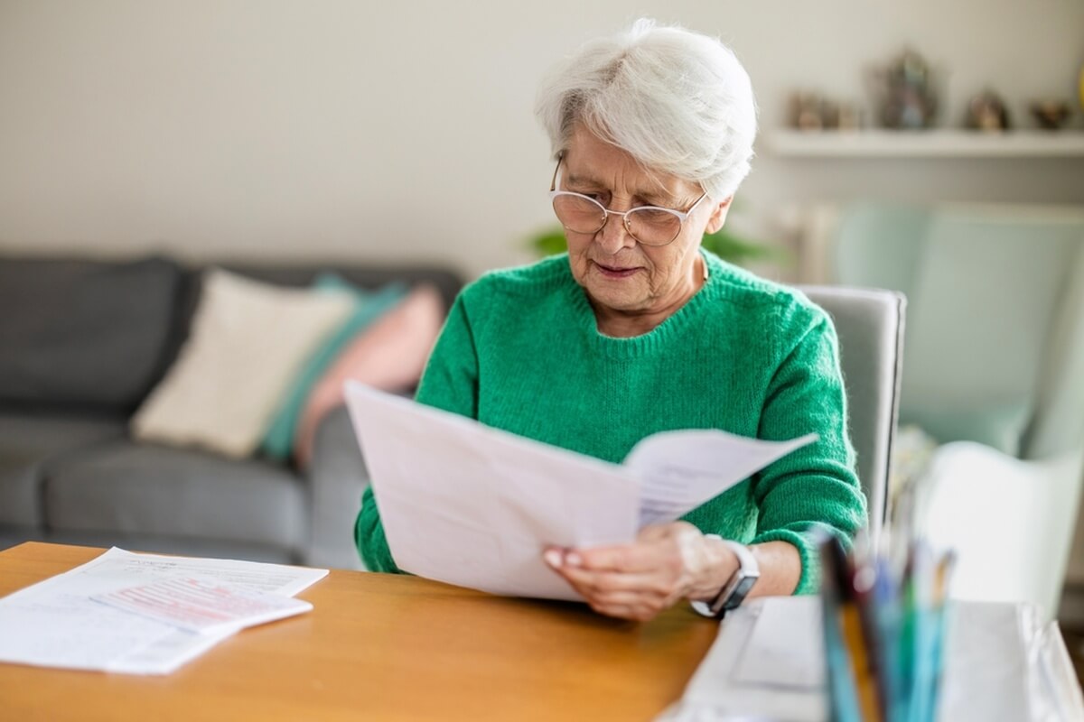Femme senior consultant ses documents pour une demande d'ASPA © pikselstock/Shutterstock