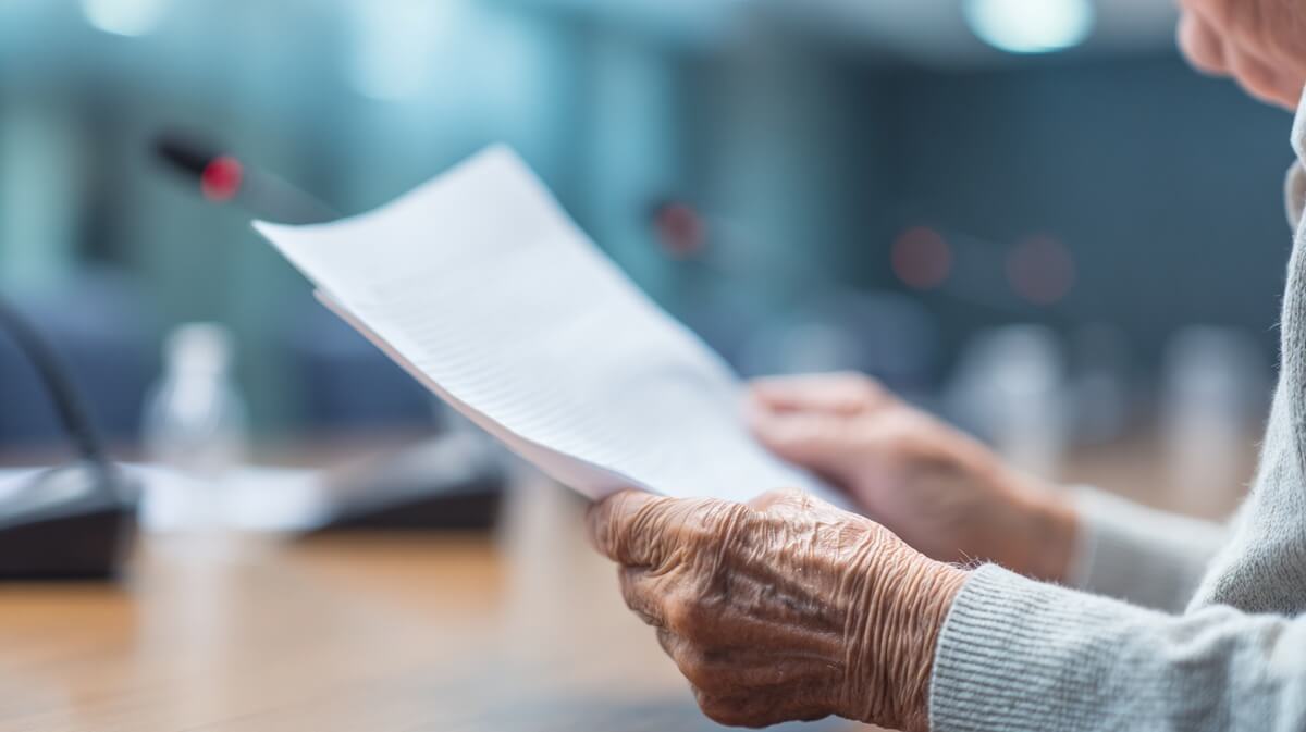 Membre du COR tenant un document de travail dans une salle de négociation vide © SeniorActu