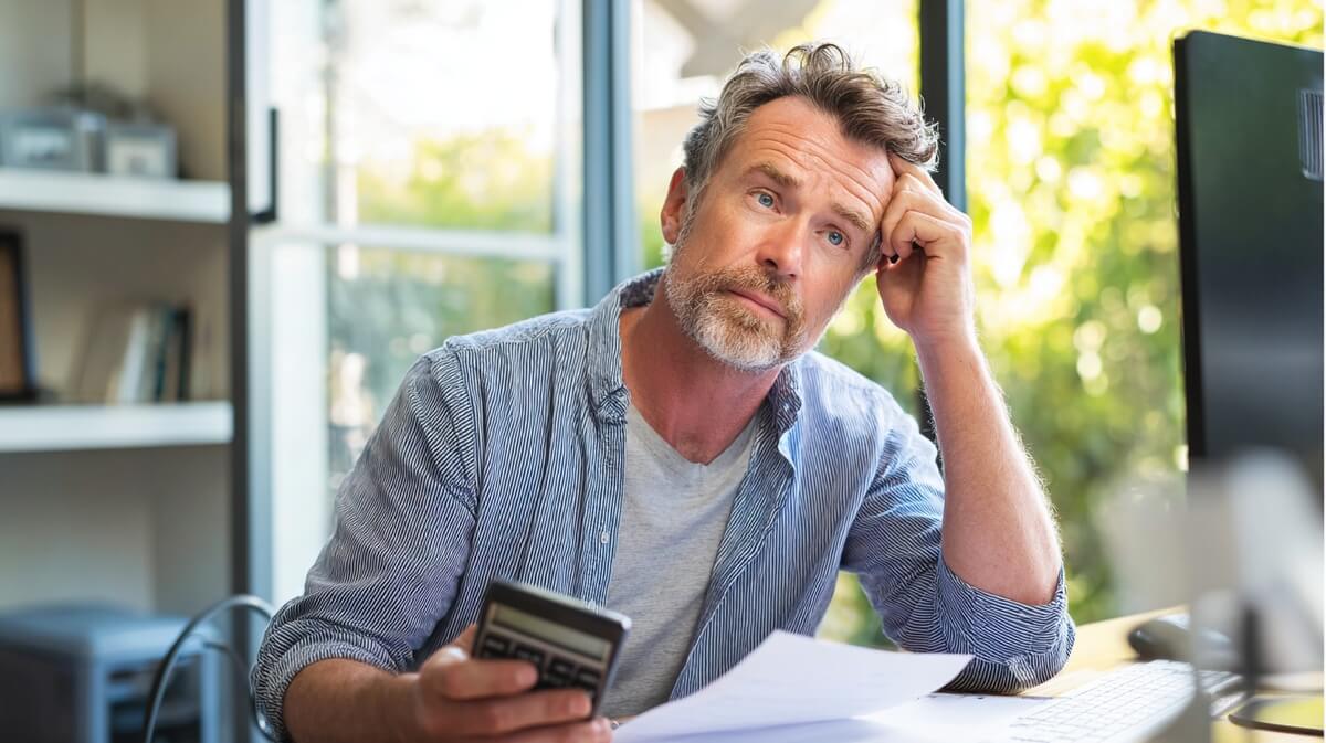 Homme de 55 ans calculant le coût d'un rachat de trimestres retraite © SeniorActu