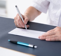 senior remplissant un chèque © Andrey_Popov/Shutterstock